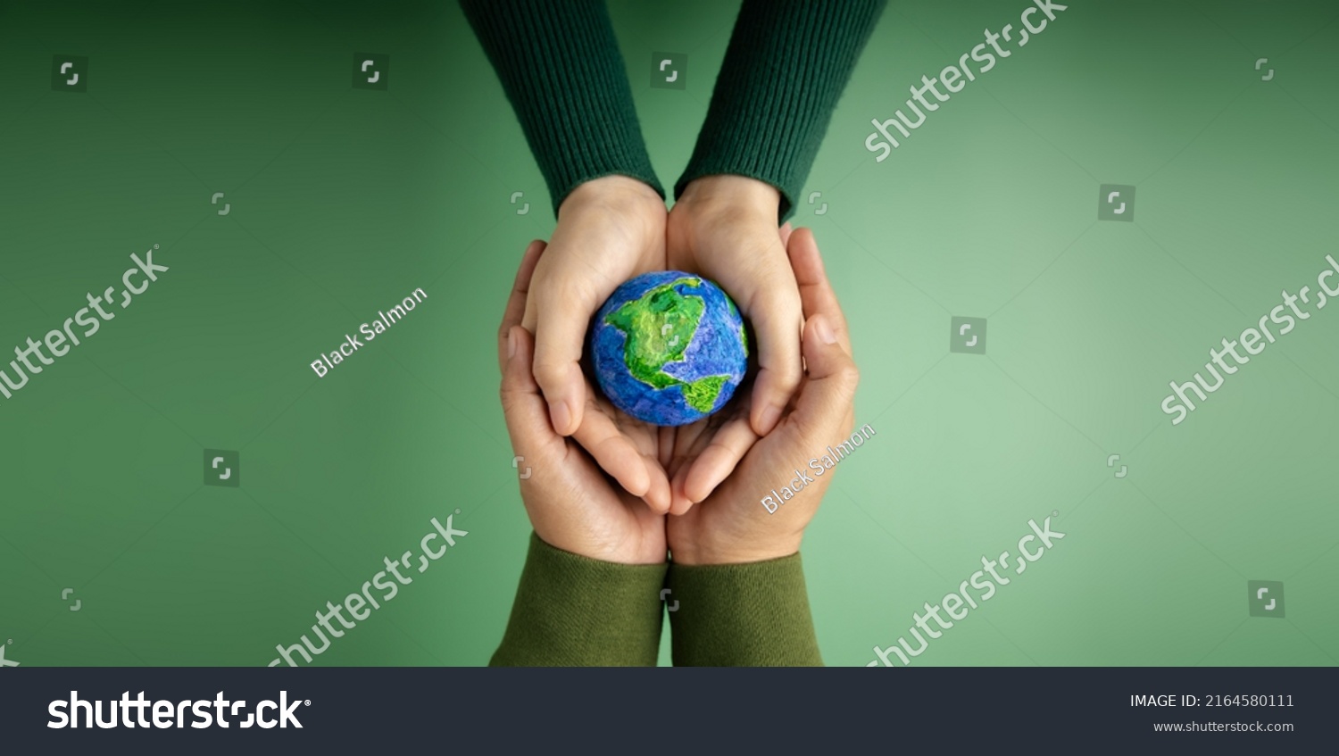World Earth Day Concept. Green Energy, ESG, Renewable and Sustainable Resources. Environmental Care. Hands of People  Embracing a Handmade Globe. Protecting Planet Together. Top View #2164580111