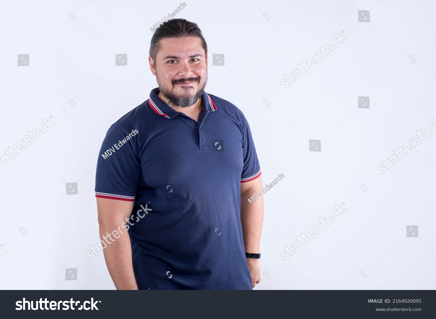 A bearded chubby man of mixed ancestry in his 30s. Wearing a blue polo shirt. Isolated on a white background. #2164920095