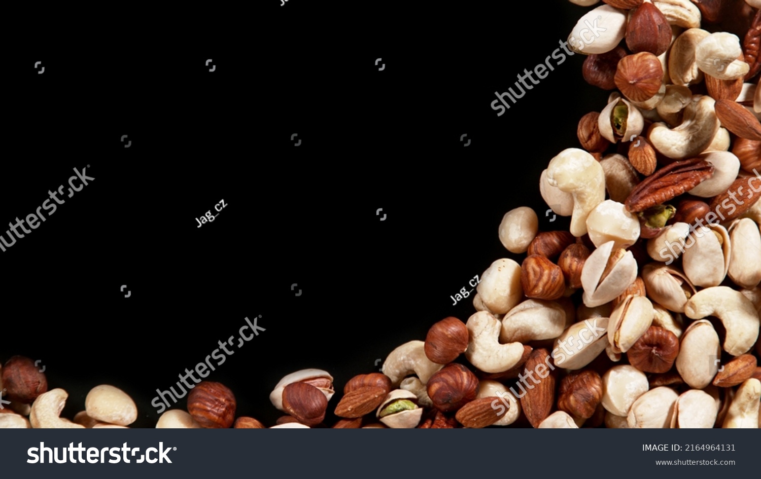 Nuts mix islated on black background, top view with copyspace. Assorted mixed nuts isolated on dark table. #2164964131