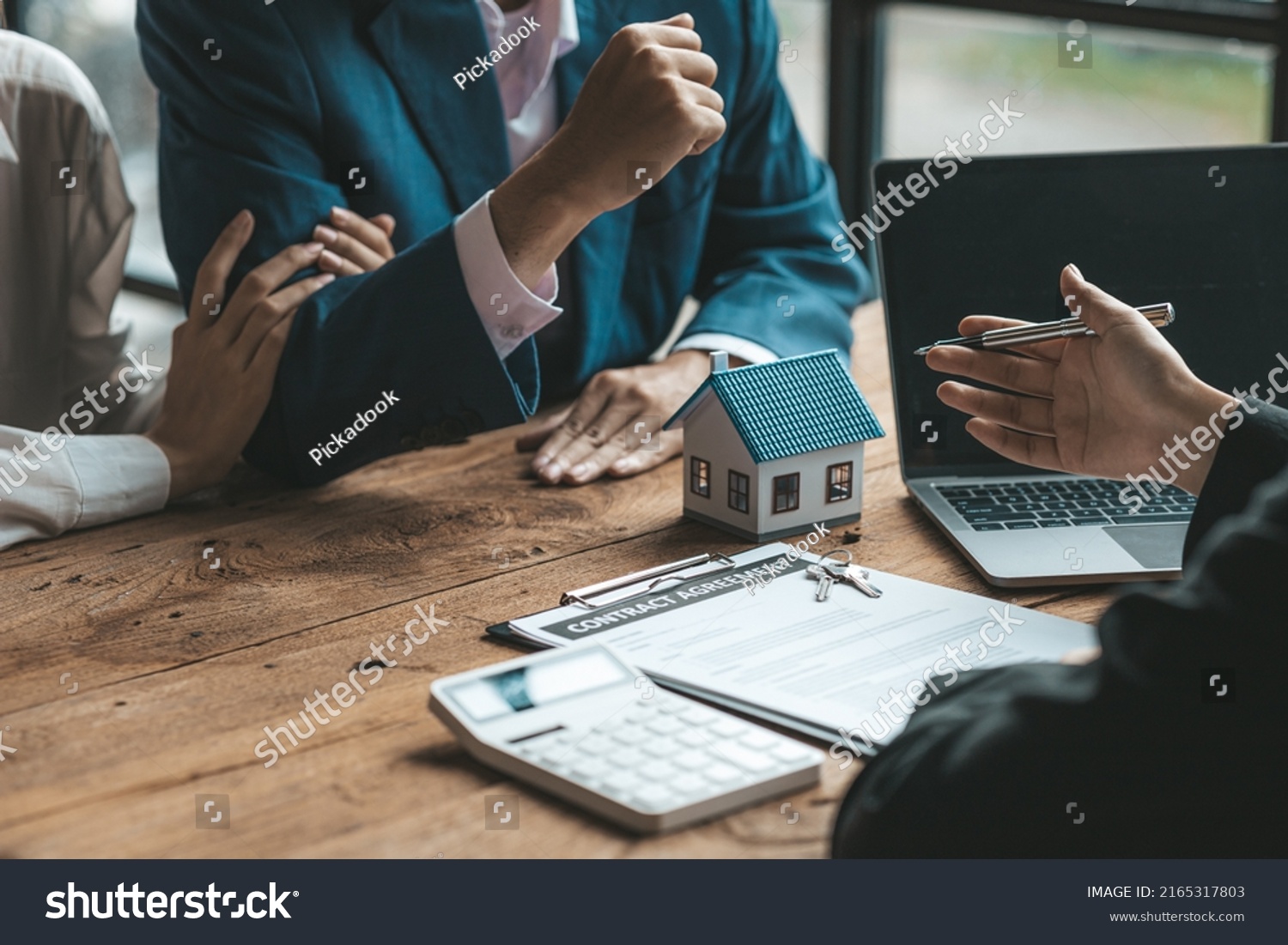 A couple is approaching a housing project to buy, and they are discussing details and advice with a salesperson in a housing project. Real estate trading ideas with couples. #2165317803