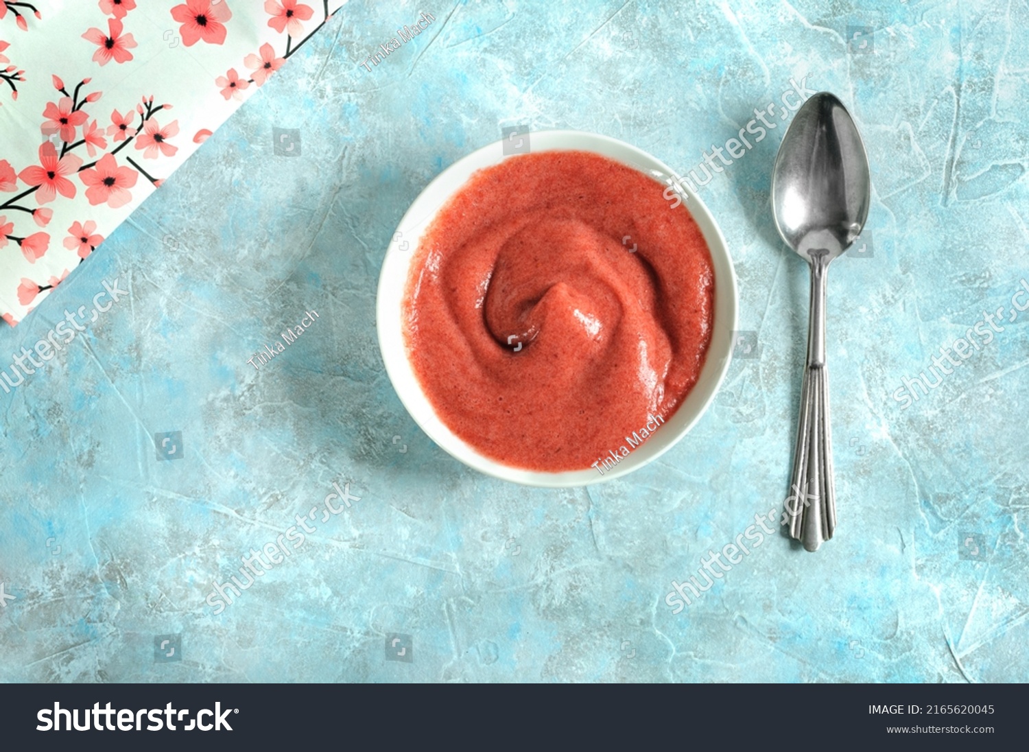 Yogurt, cream, mousse or smoothie in a white ceramic plate with a spoon on a blue marble background. Daylight, selective focus. View from above #2165620045
