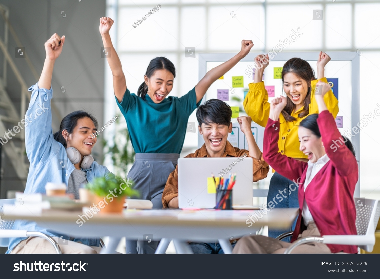 Young happy Asian business man, woman work together, celebrate success in start up office. Creative team brainstorm meeting, businesspeople colleague partnership or office coworker teamwork concept #2167613229