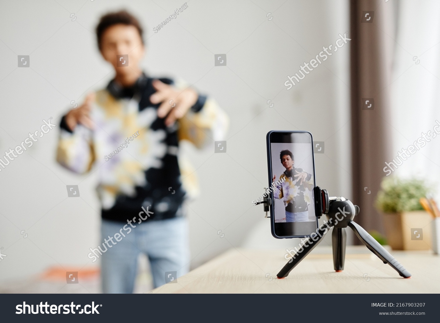 Background image of Gen Z teenager filming video for social media at home, focus on smartphone screen, copy space #2167903207