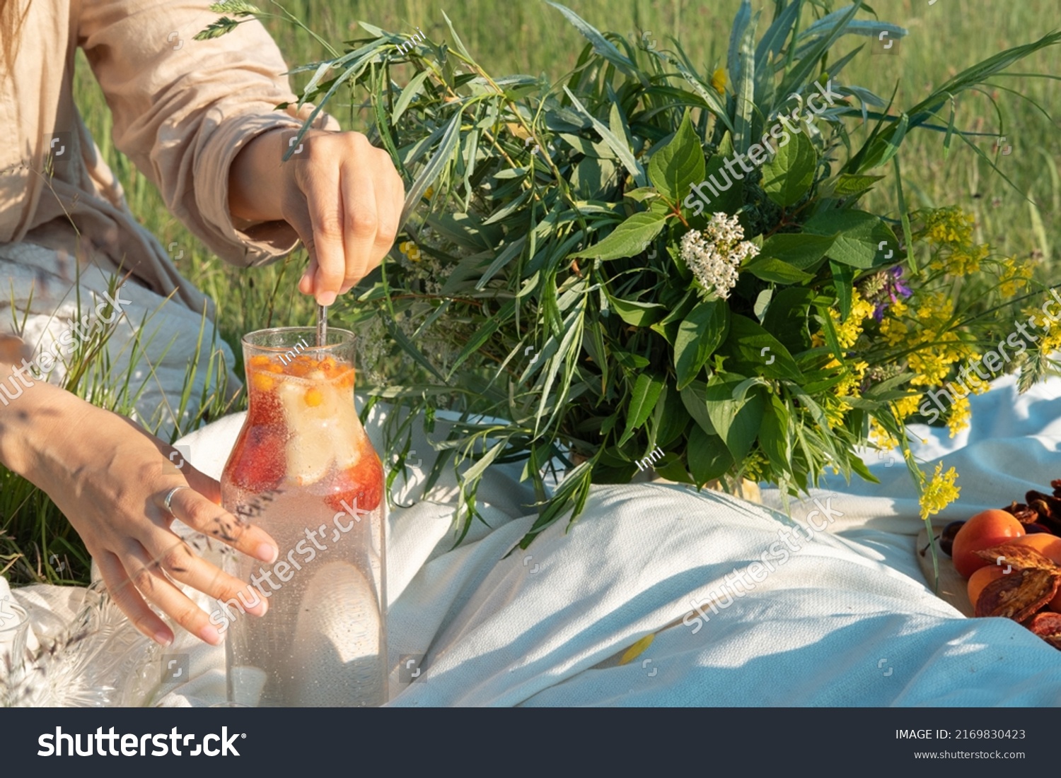 Unrecognized woman making a refreshing drink from strawberries at a picnic. #2169830423