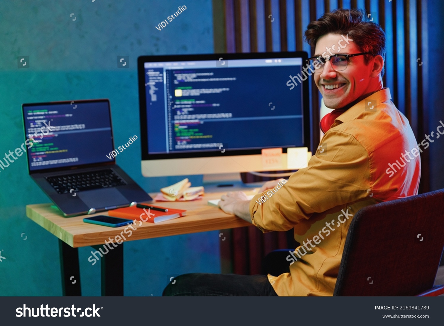 Side back view smiling young full-stack developer software engineer IT specialist programmer man in shirt work at home writing code on laptop pc computer checking database. Program development concept #2169841789