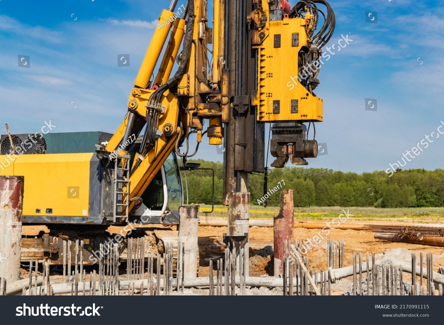 Hydraulic drilling machine at the construction site. Pile field. Modern drilling rig. The device of piles on the background of the blue sky. Work drilling rig when driving bored piles #2170991115