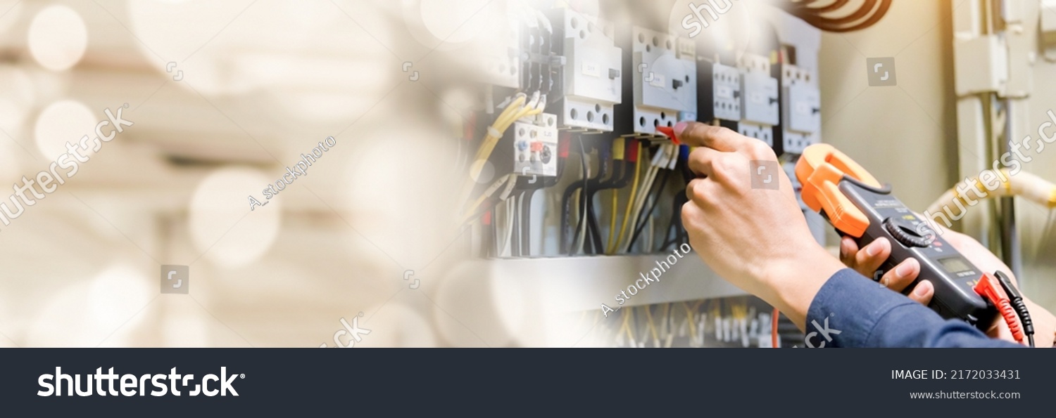 Electrician engineer work  tester measuring  voltage and current of power electric line in electrical cabinet control. #2172033431