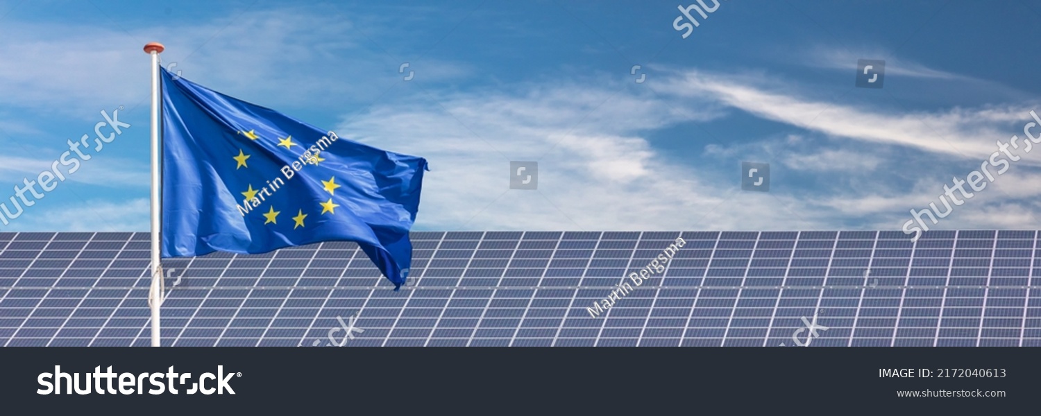 Official flag of the European Union in front of a large array of solar panels #2172040613
