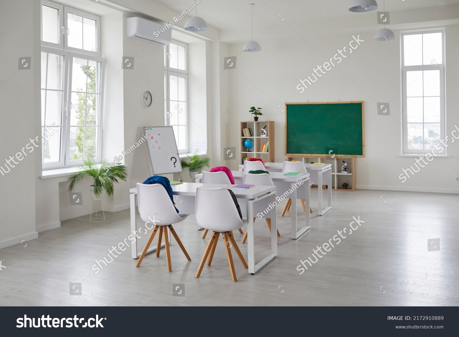 Classroom school.Interior of clean spacious classroom ready for new school year. Empty room with white walls, comfortable desks, chairs, green blackboard, whiteboard. Back to school. #2172910889