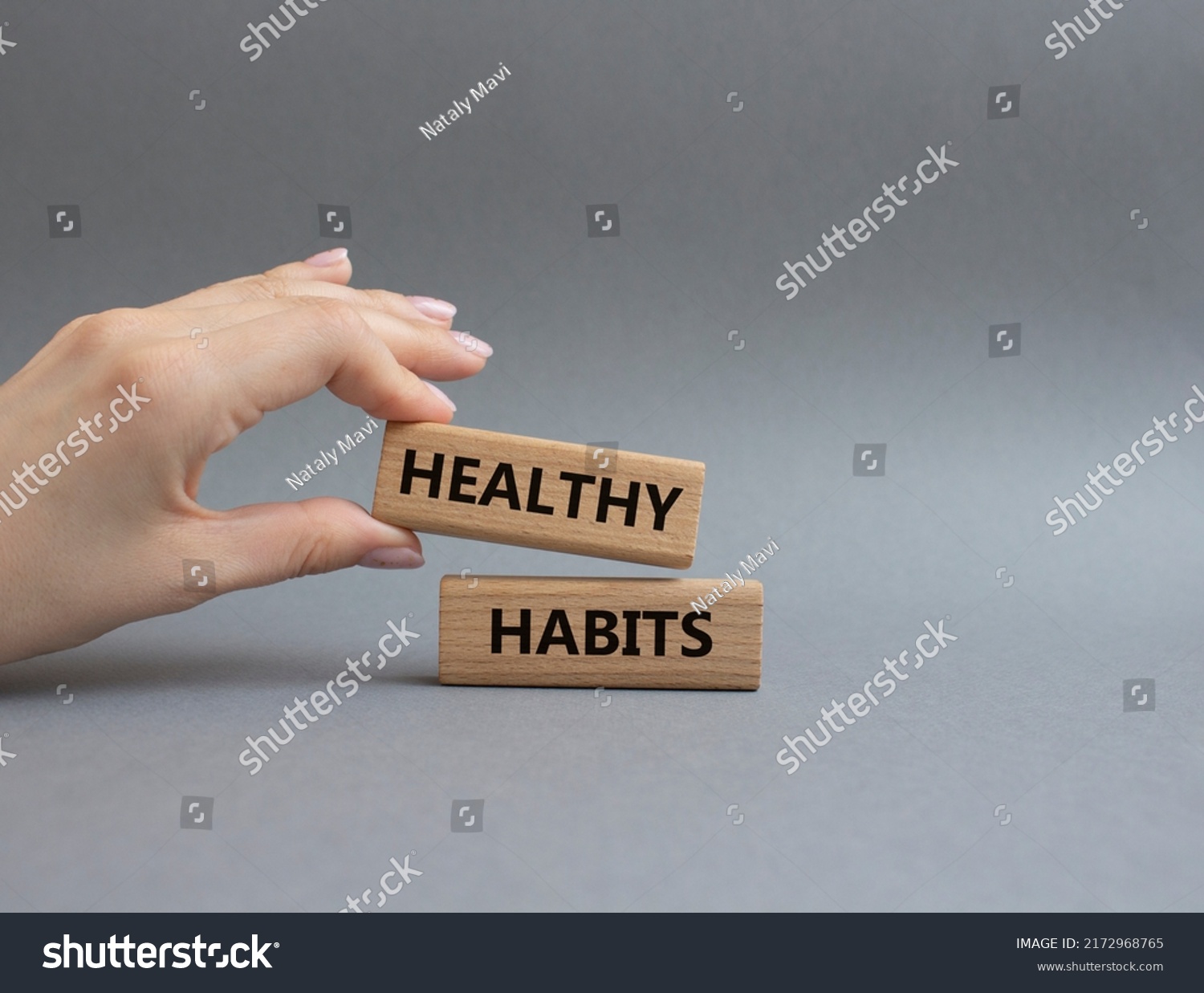 Healthy habits symbol. Concept word Healthy habits on wooden blocks. Beautiful grey background. Businessman hand. Business and Healthy habits concept. Copy space #2172968765