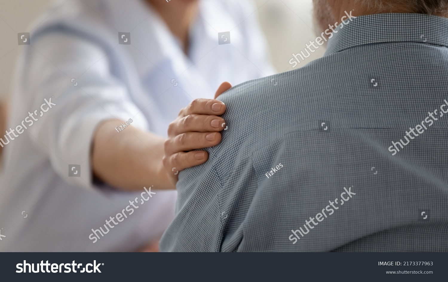 Close up caring doctor touching mature patient shoulder, expressing empathy and support, young woman therapist physician comforting senior aged man at meeting, medical healthcare and help #2173377963