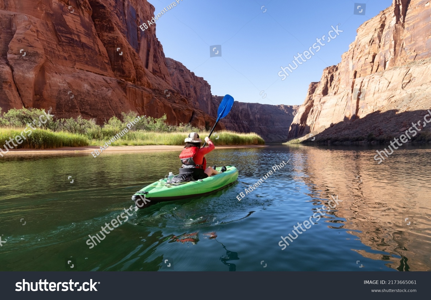Adventurous Woman on a Kayak paddling in Colorado River. Glen Canyon, Arizona, United States of America. American Mountain Nature Landscape Background. Adventure Travel #2173665061