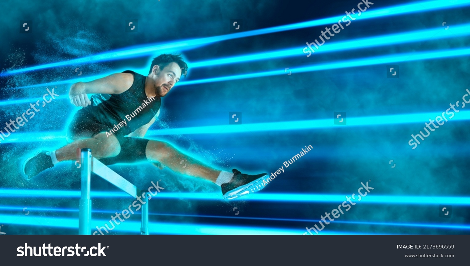 Young male athlete at hurdle race, jumping over the last hurdle. Blue neon background. Sport banner, flyer #2173696559
