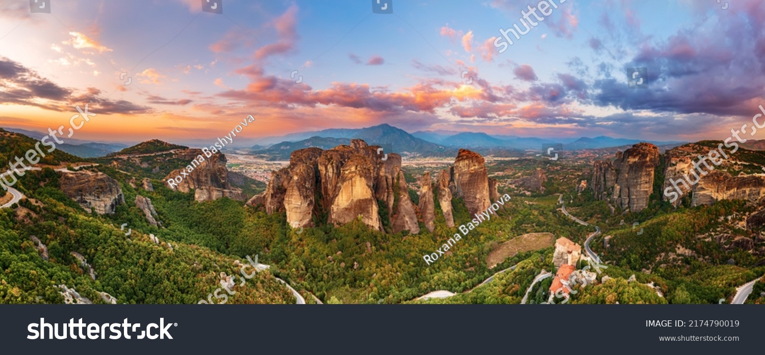 Meteora, Greece. Sandstone rock formations, the Rousanou and Nikolaos monasteries at sunset. Travel destination background. Panoramic view. #2174790019