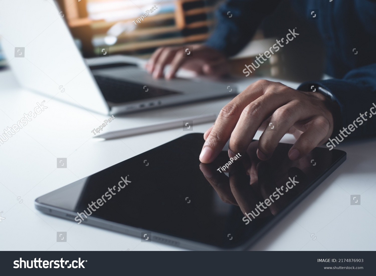 Man using digital tablet, working on laptop computer on office table. Casual business man touching on tablet screen, surfing the internet, online job, freelance at work, close up #2174876903
