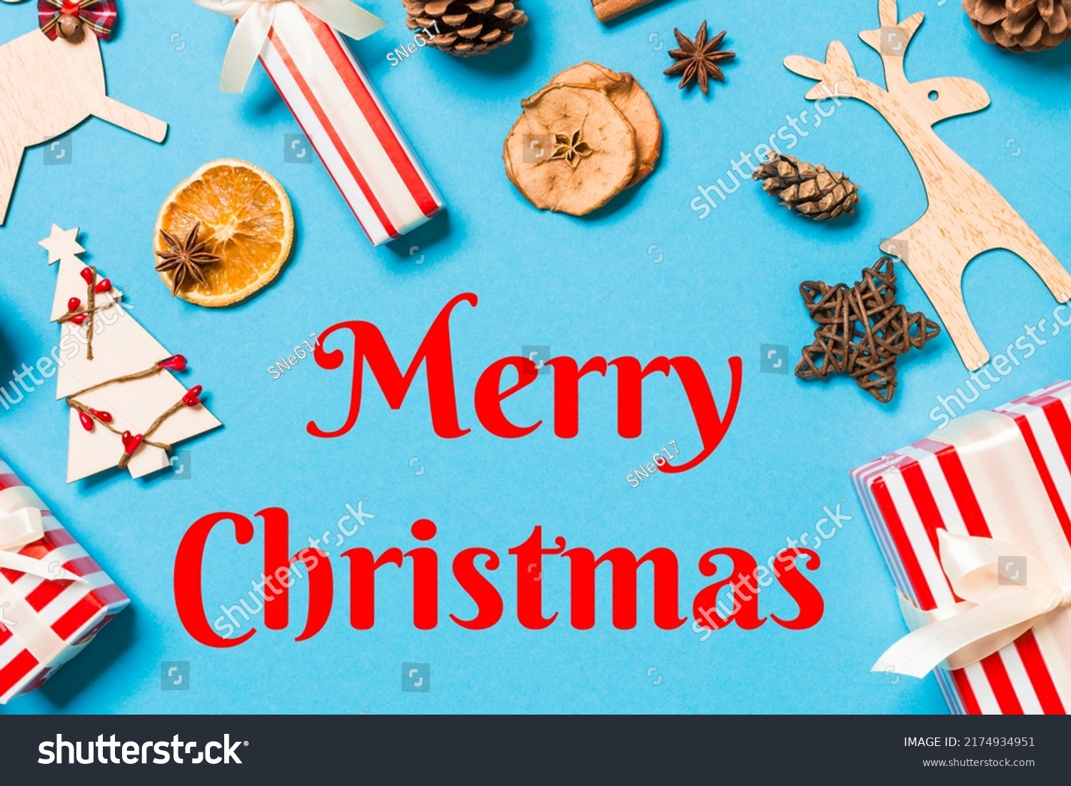 Merry Christmas text. Top view of Christmas decorations on blue background. New Year holiday concept with copy space. #2174934951