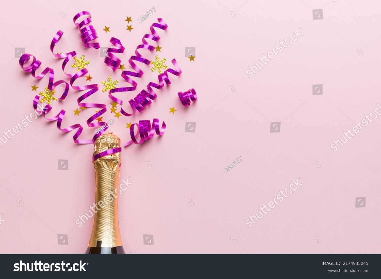 Creative flat lay composition with bottle of champagne and space for text on color background. Champagne bottle with colorful party streamers. holiday or christmas concept. #2174935045