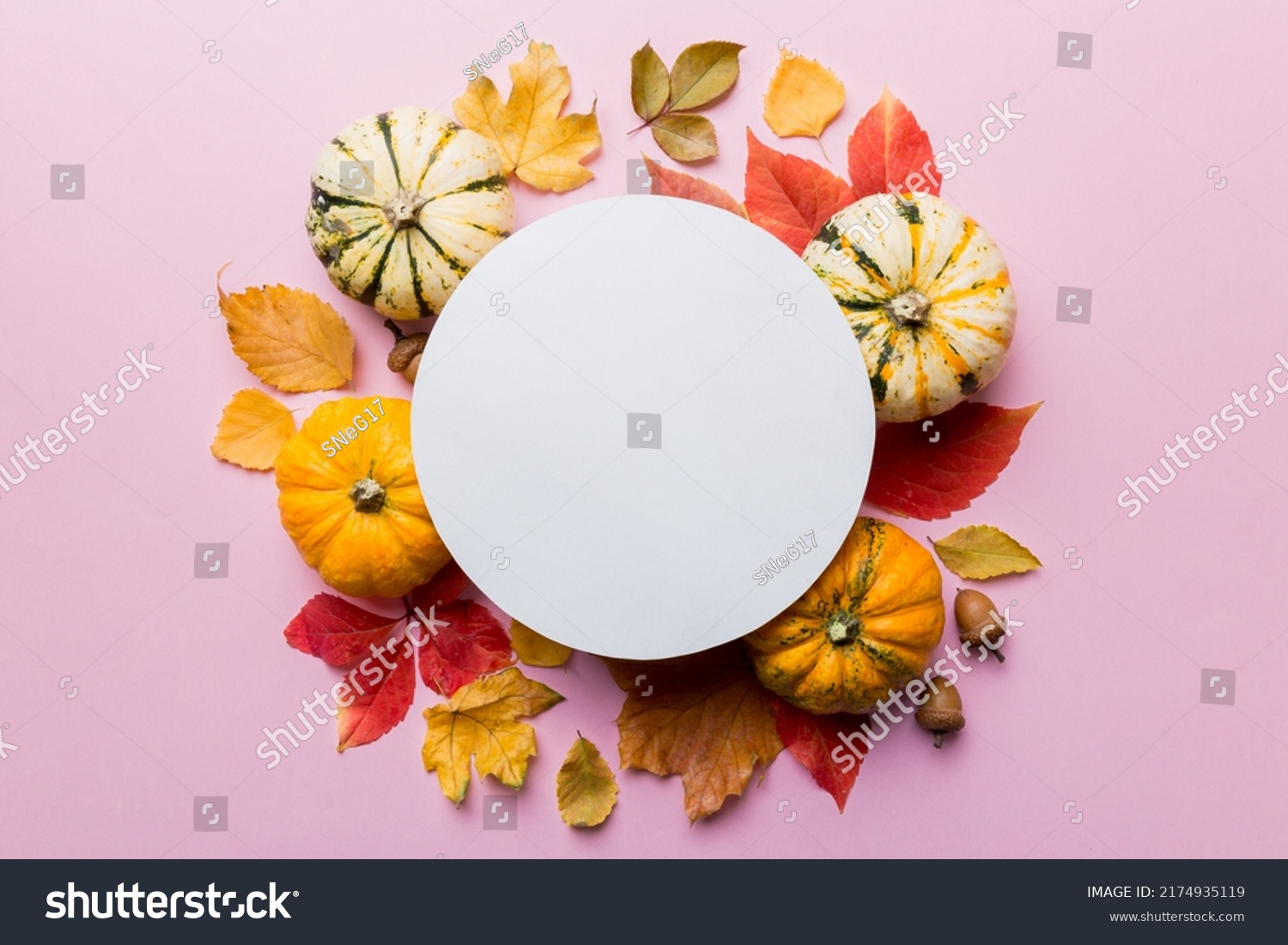 Autumn composition with round paper blank and dried leaves with pumpkin on table. Flat lay, top view, copy space. #2174935119