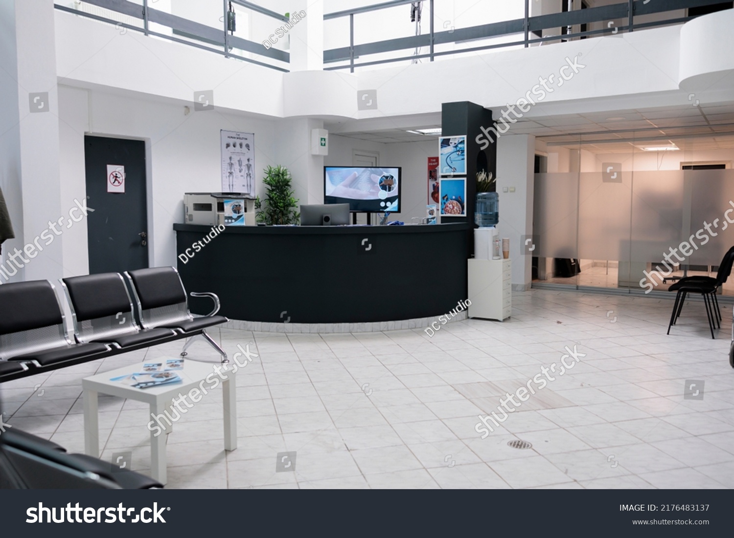 No people in waiting area for patients with doctor appointments in modern healthcare clinic in private practice hopital. Empty waiting room with front desk reception with promotional flyers. #2176483137