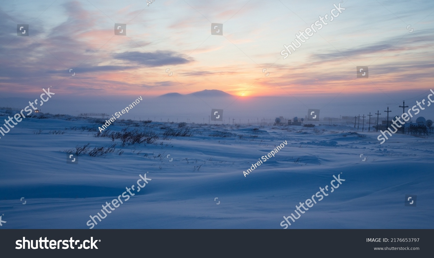 Winter arctic landscape. Sunset in the tundra. Early winter twilight. Cold frosty winter weather. Electric poles and satellite dishes in the snowy tundra. Chukotka, Siberia, Far East of Russia, Arctic #2176653797