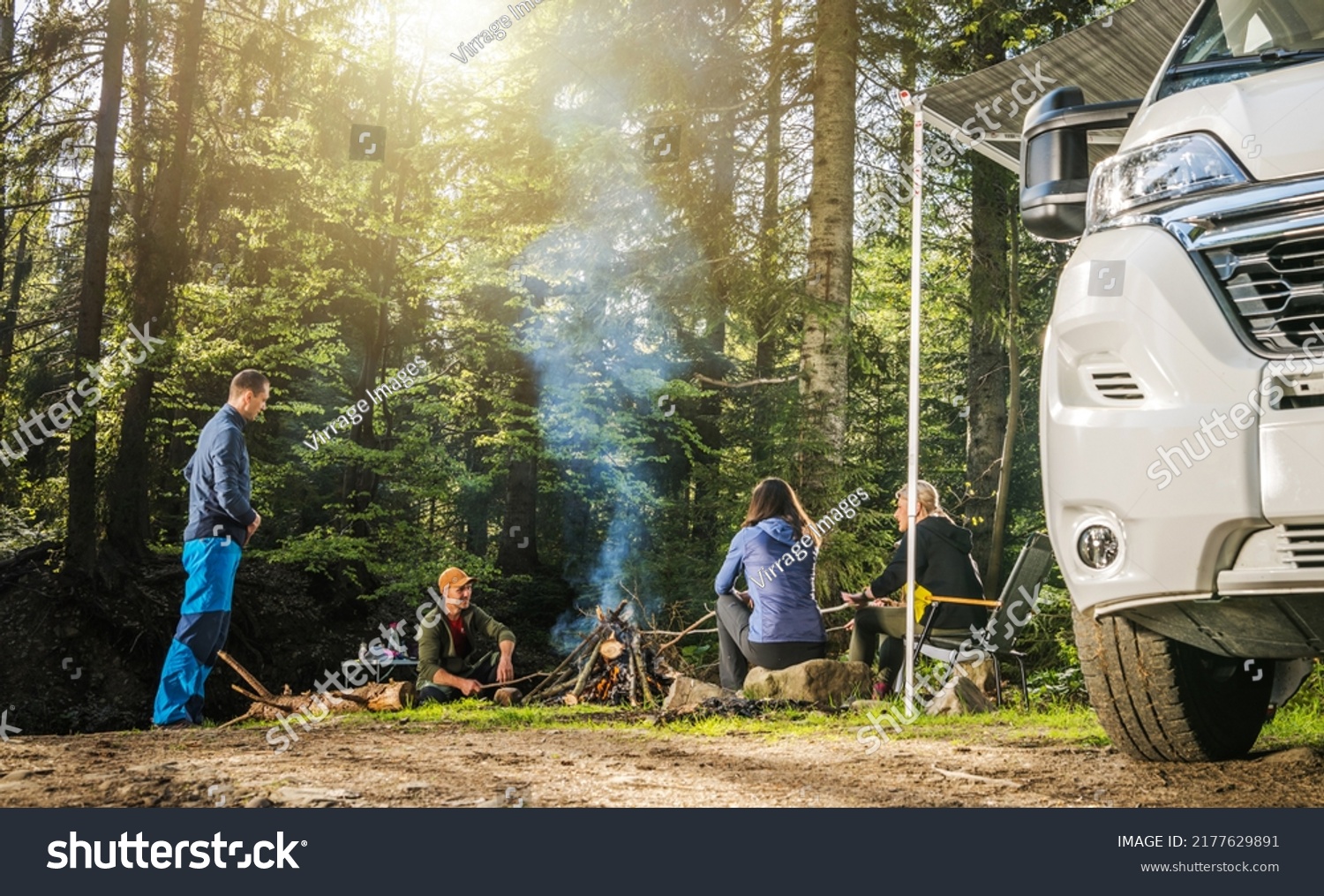 Four Adult Caucasian Friends in Their 40s Hanging Out Next to Campfire During Wilderness Boondocking Camper Camping #2177629891