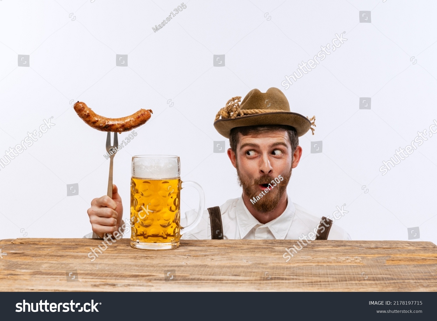 Wow. Happy man wearing traditional fest Bavarian or German outfit with big beer glass and fried sausage celebrating Oktoberfest. Alcohol, traditions, holidays, taste concept. Copy space for ad #2178197715