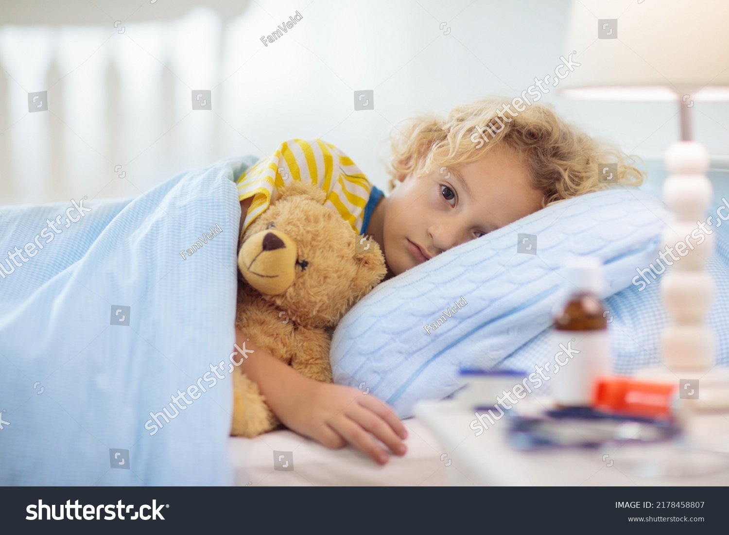 Sick little boy with asthma medicine. Ill child lying in bed. Unwell kid with chamber inhaler for cough treatment. Flu season. Bedroom or hospital room for young patient. Healthcare and medication. #2178458807