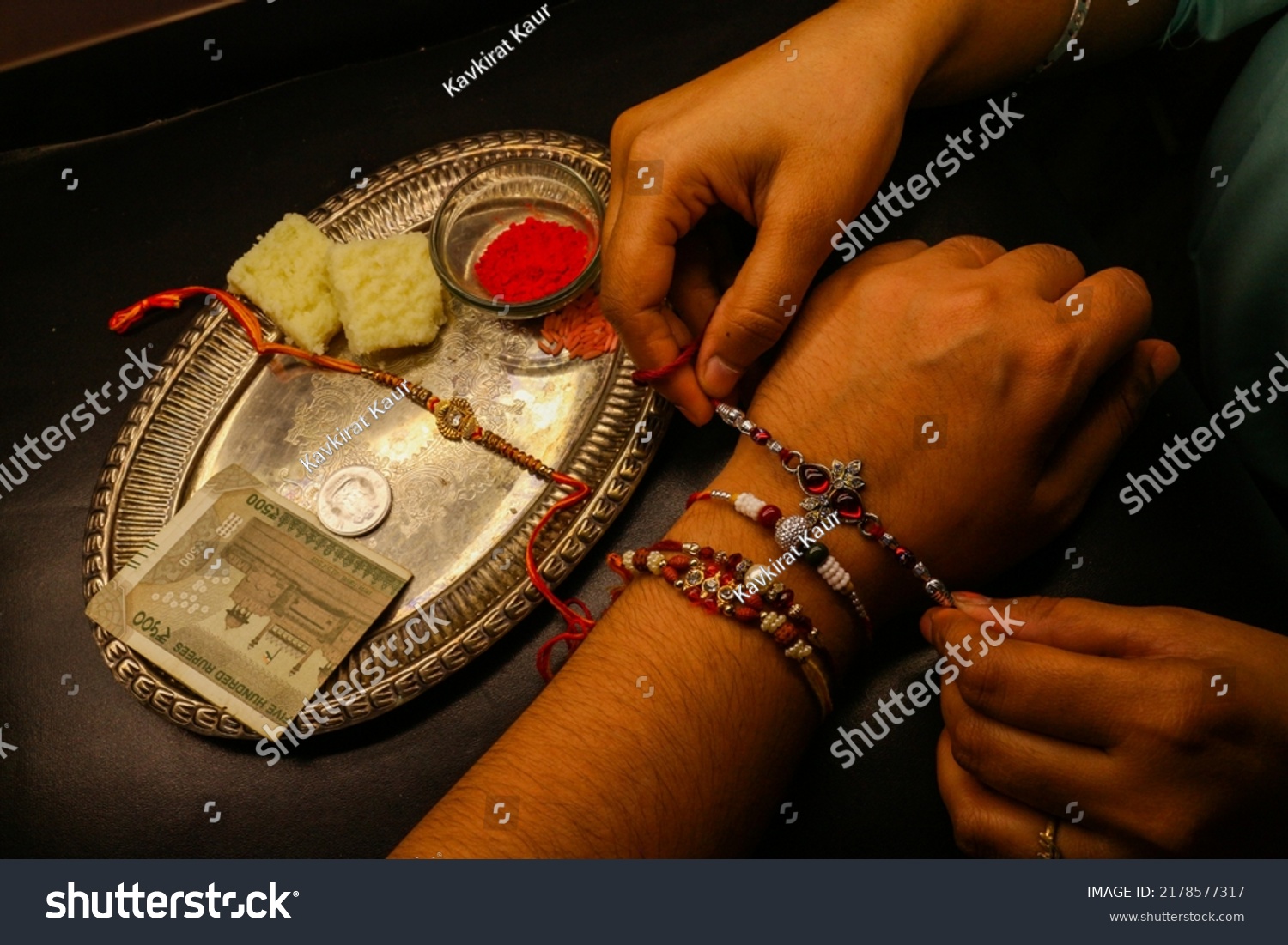 Brother sister love bond sister tying rakhi on brother's hand with shagun and rakhi thali Indian festival #2178577317