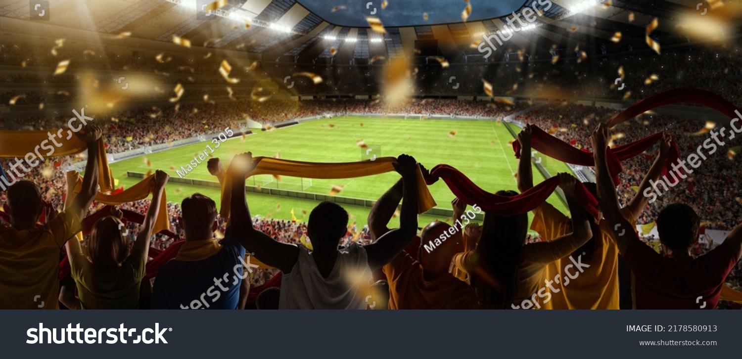 Support. Back view of football, soccer fans cheering their team with colorful scarfs at crowded stadium at evening time. Concept of sport, cup, world, team, event, competition #2178580913