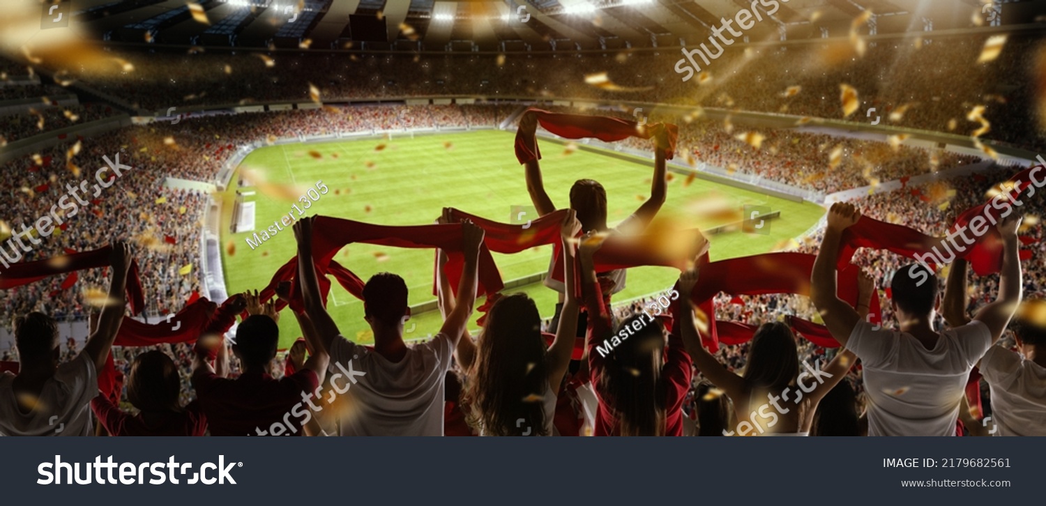 Sport match. Back view of football, soccer fans cheering their team with colorful scarfs at crowded stadium at evening time. Concept of sport, cup, world, team, event, competition #2179682561