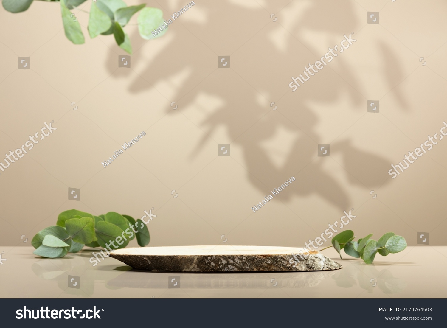 Minimal modern product display on neutral beige background. Wood slice podium and green leaves. Concept scene stage showcase for new product, promotion sale, banner, presentation, cosmetic #2179764503