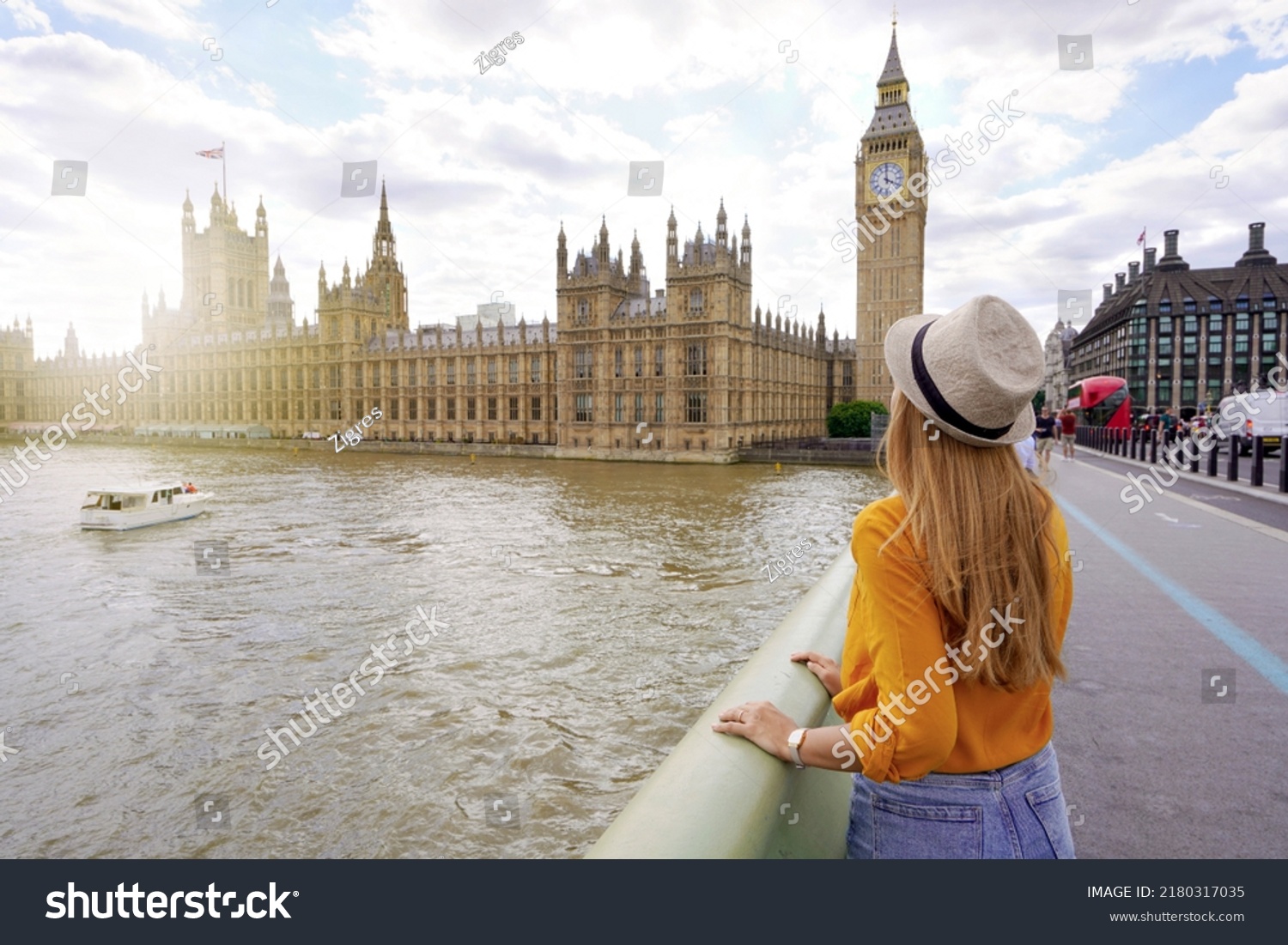 Tourism in London. Back view of traveler girl enjoying sight of Westminster palace and bridge on Thames with famous Big Ben tower in London, UK. #2180317035