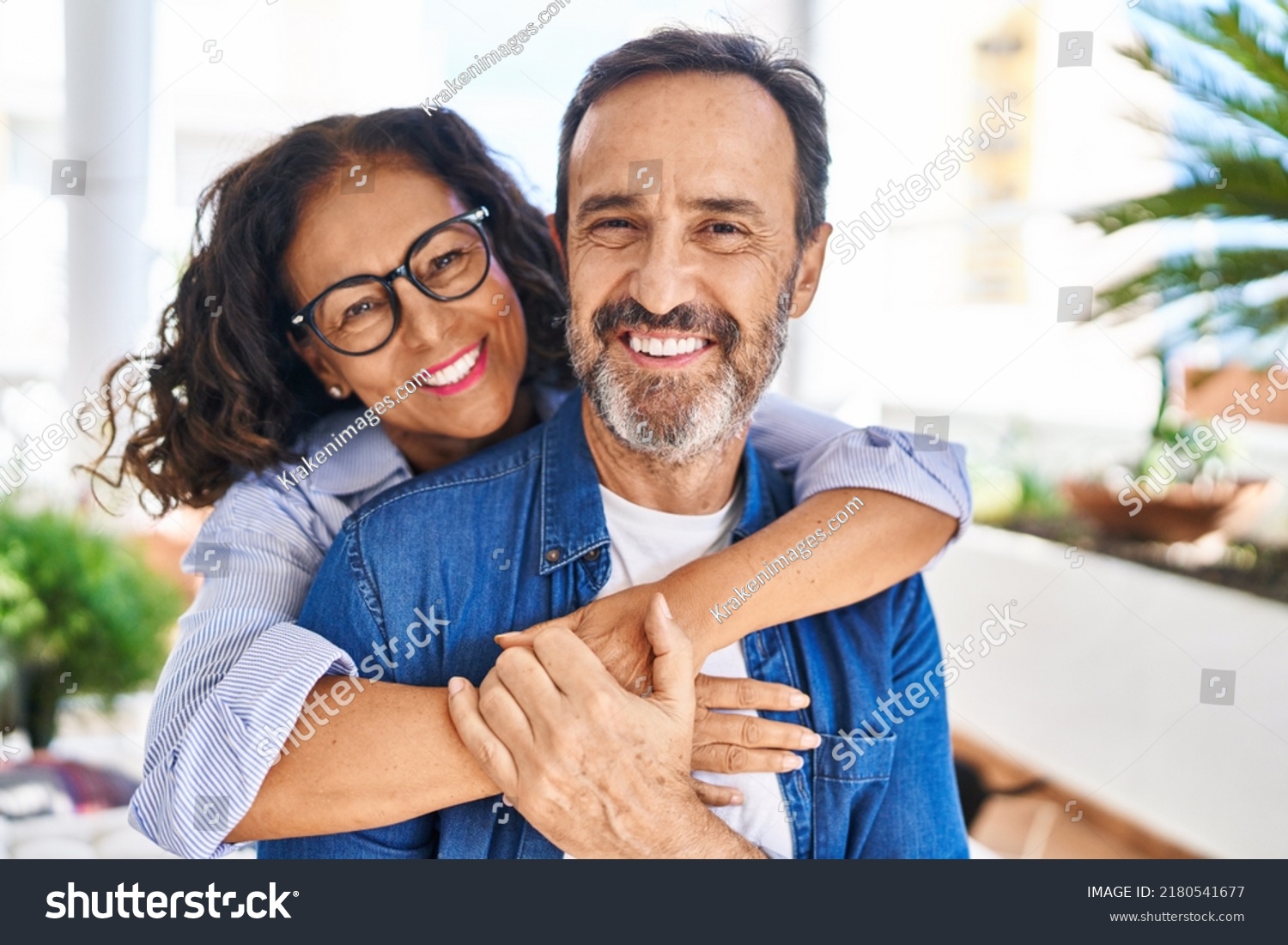 Middle age hispanic couple smiling confident hugging each other sitting on hammock at terrace #2180541677