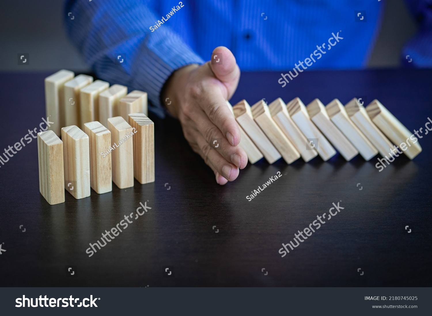 Business Risks and Strategies hand stop falling wooden block domino Consequences of falling blocks defense and development for security Prevention and problem solving concepts #2180745025