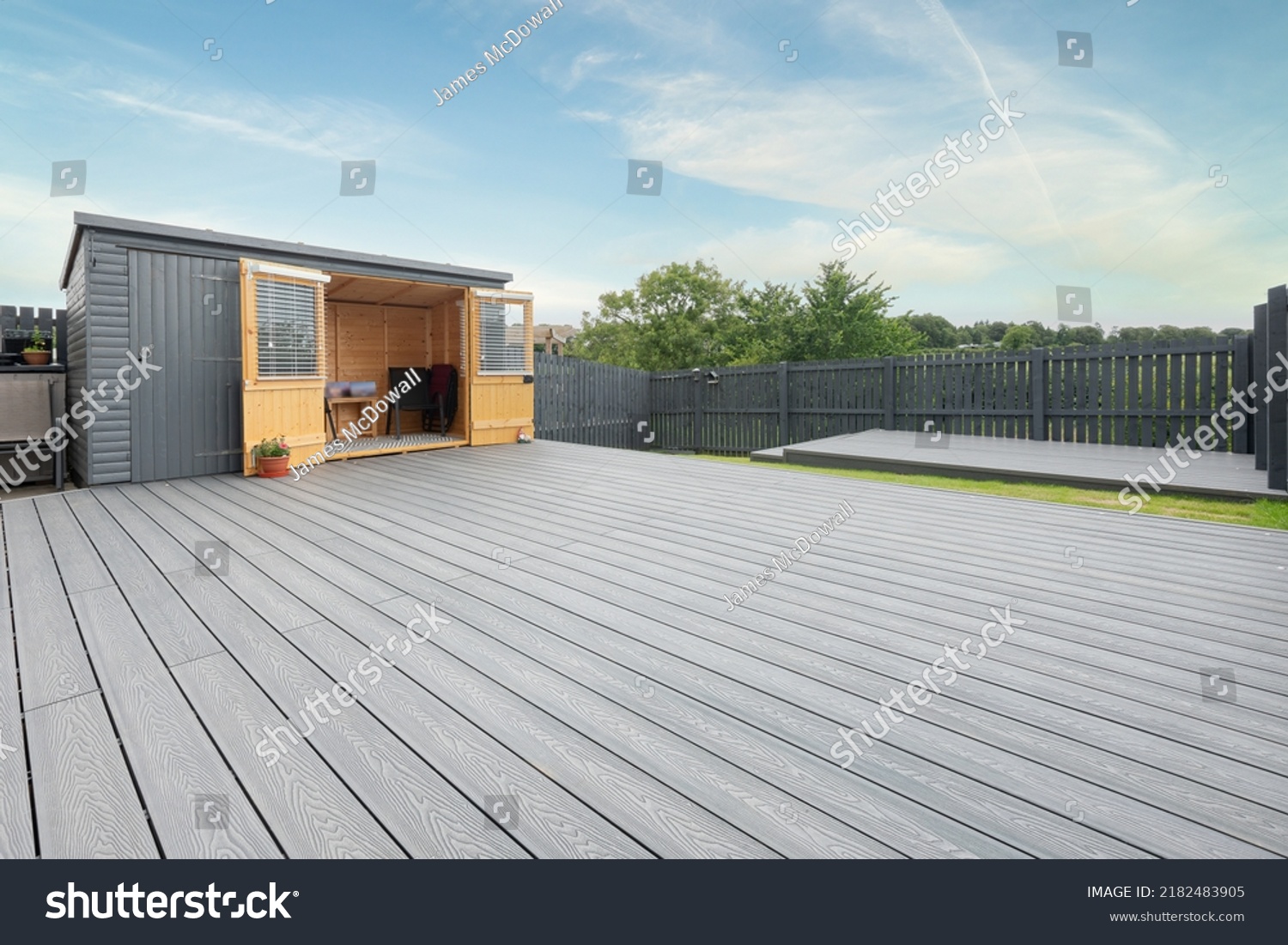 Ash grey composite decking built on two levels on a residential back garden with low voltage deck lights installed as well. Good Image for a landscape Gardiner #2182483905
