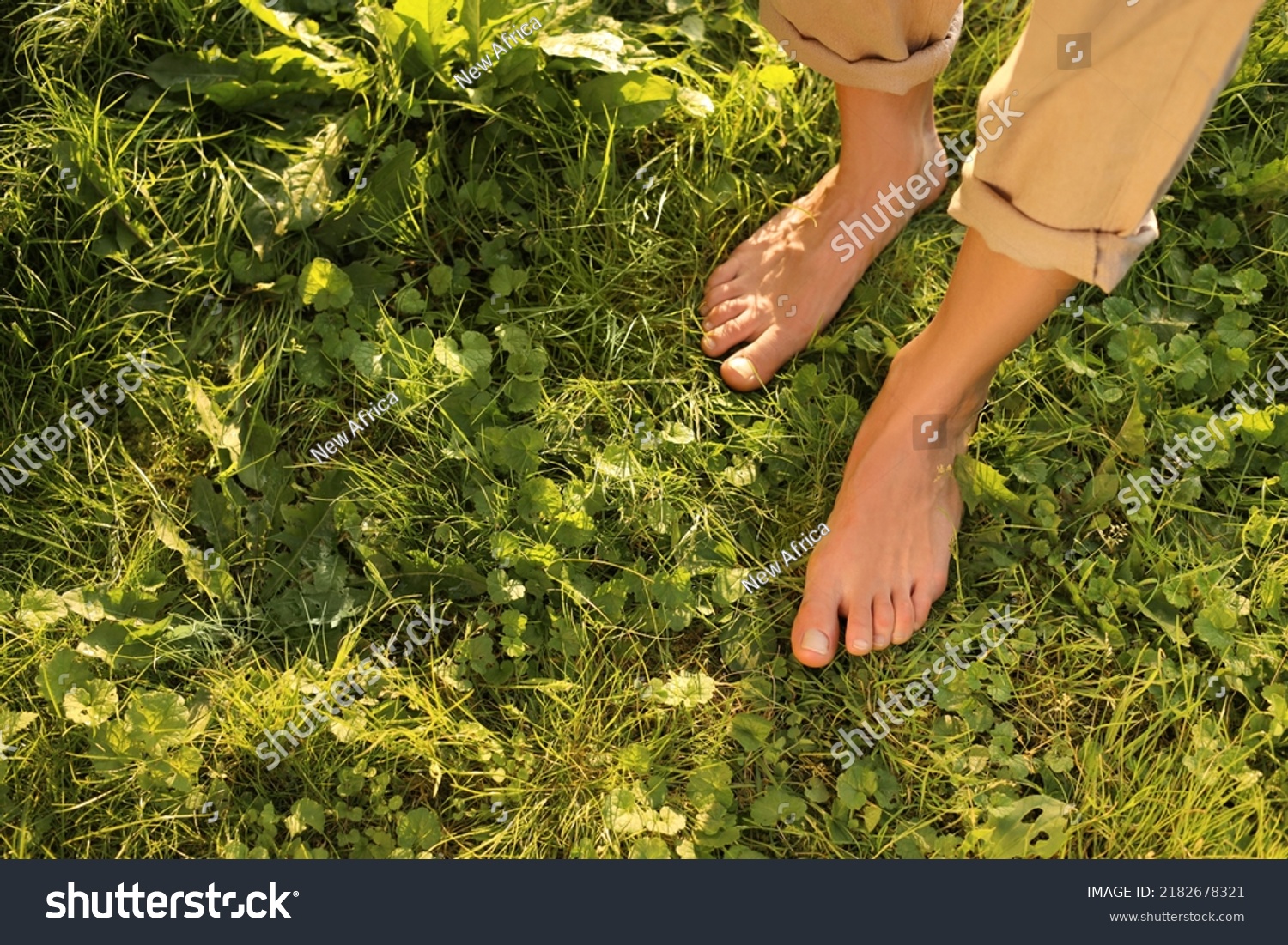 Woman walking barefoot on green grass outdoors, above view. Space for text #2182678321