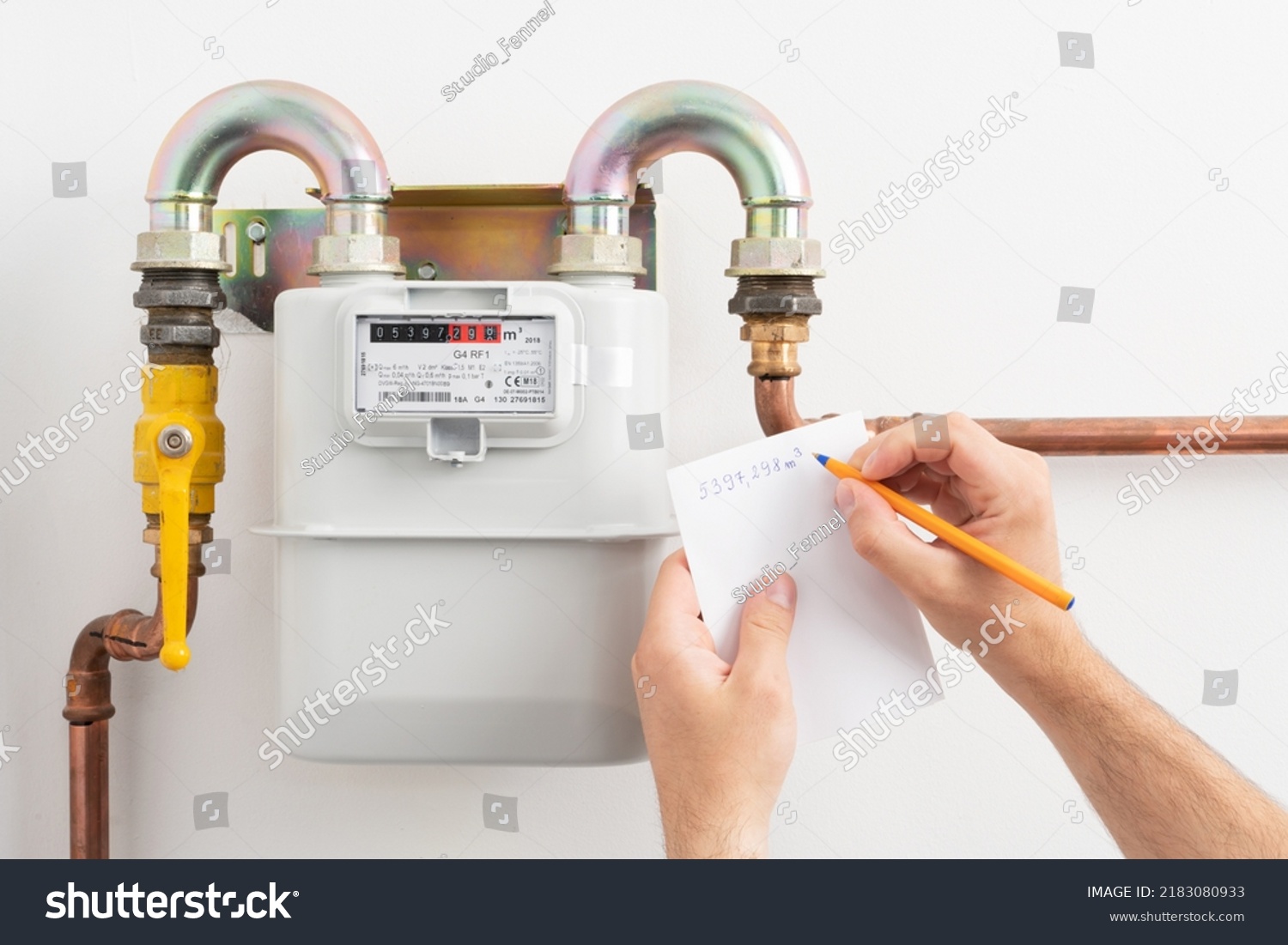 Young man reading the gas meter in the private house, counter for distribution domestic gas. Inflation concept, increasing prices of natural gas.
 #2183080933