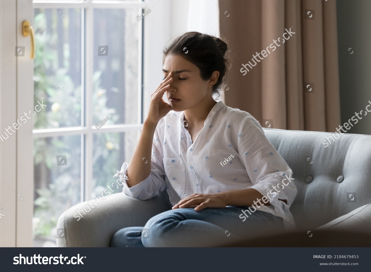 Depressed frustrated young Indian woman suffering from headache, migraine, touching face, head with closed eyes, feeling stressed, sick, tired, thinking over bad news, problems, crisis #2184679453