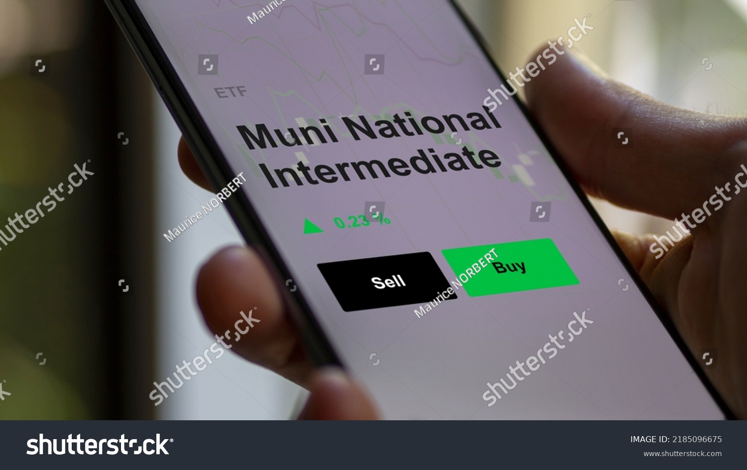 An investor's analyzing the muni national intermediate etf fund on a screen. A phone shows the prices of Muni National Intermediate #2185096675
