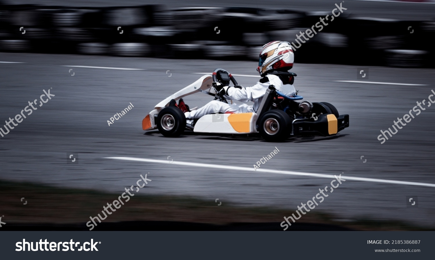 Go kart racing field, racer wearing safety uniform on competition tournament.  #2185386887