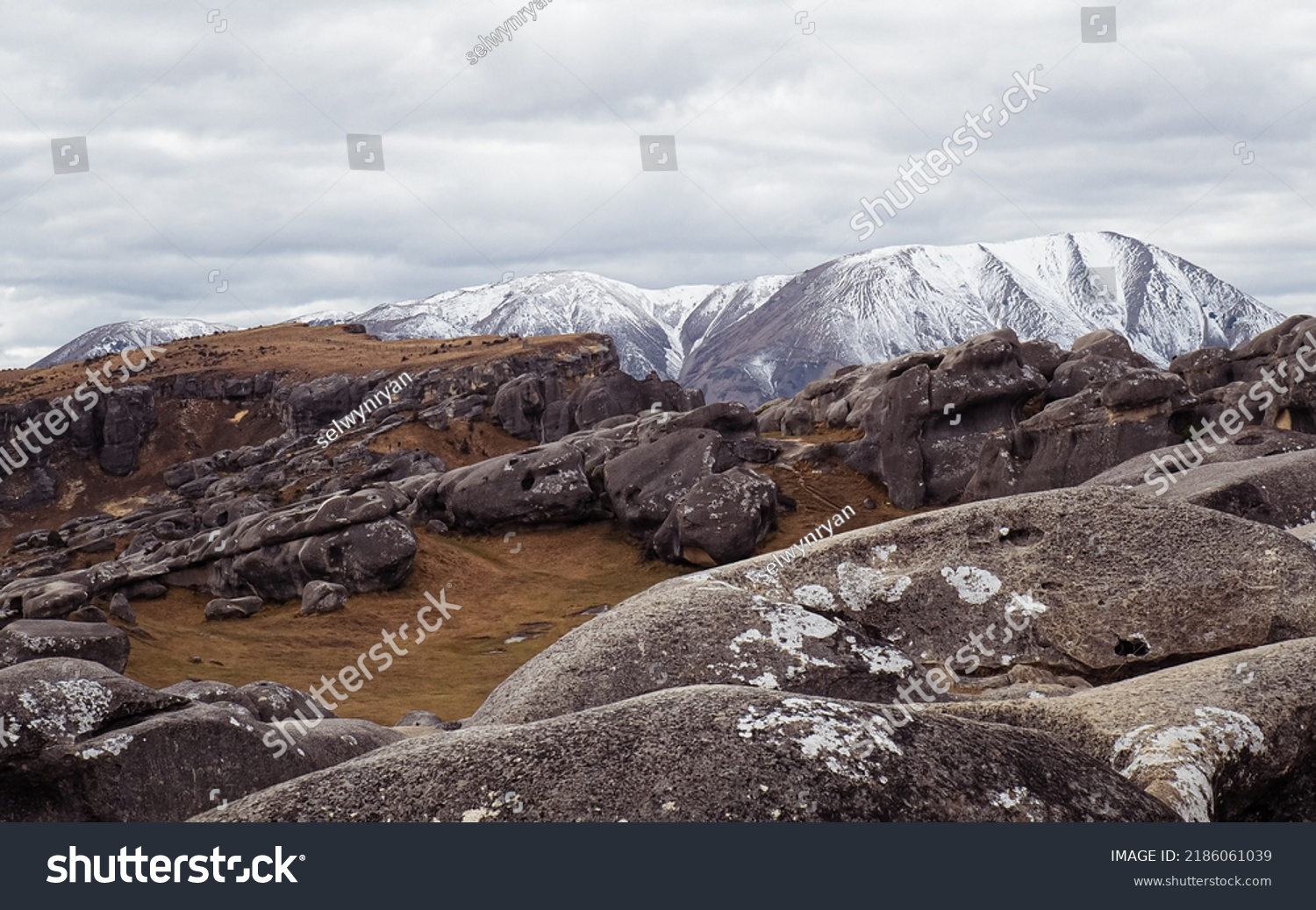 Castle Hill, Canterbury, New Zealand.

View of a beautiful rocky terrain on a cloudy day with snow topped mountains in the background. #2186061039
