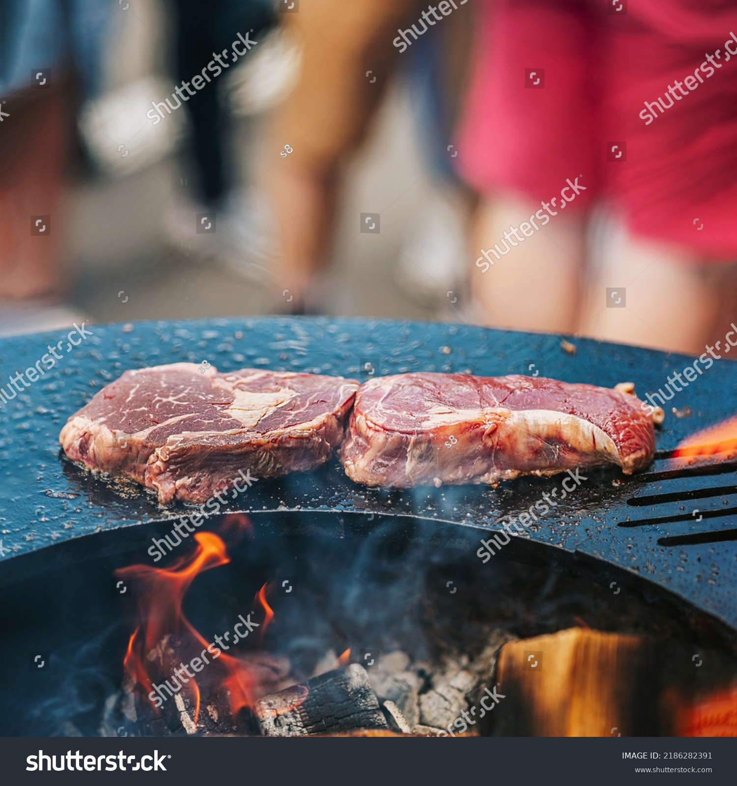 Steaks prepared on bbq grill Close-up, barbecue outdoors with fire flame. Summer picnic concept. Selective focus #2186282391