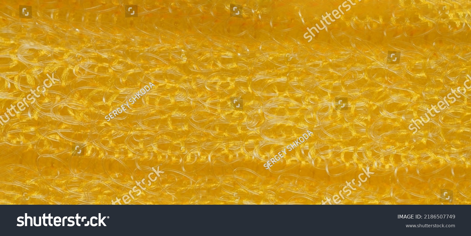 closeup, background, texture, large long horizontal banner. heterogeneous surface structure bright saturated yellow sponge for washing dishes, kitchen, bath. full depth of field. high resolution photo #2186507749