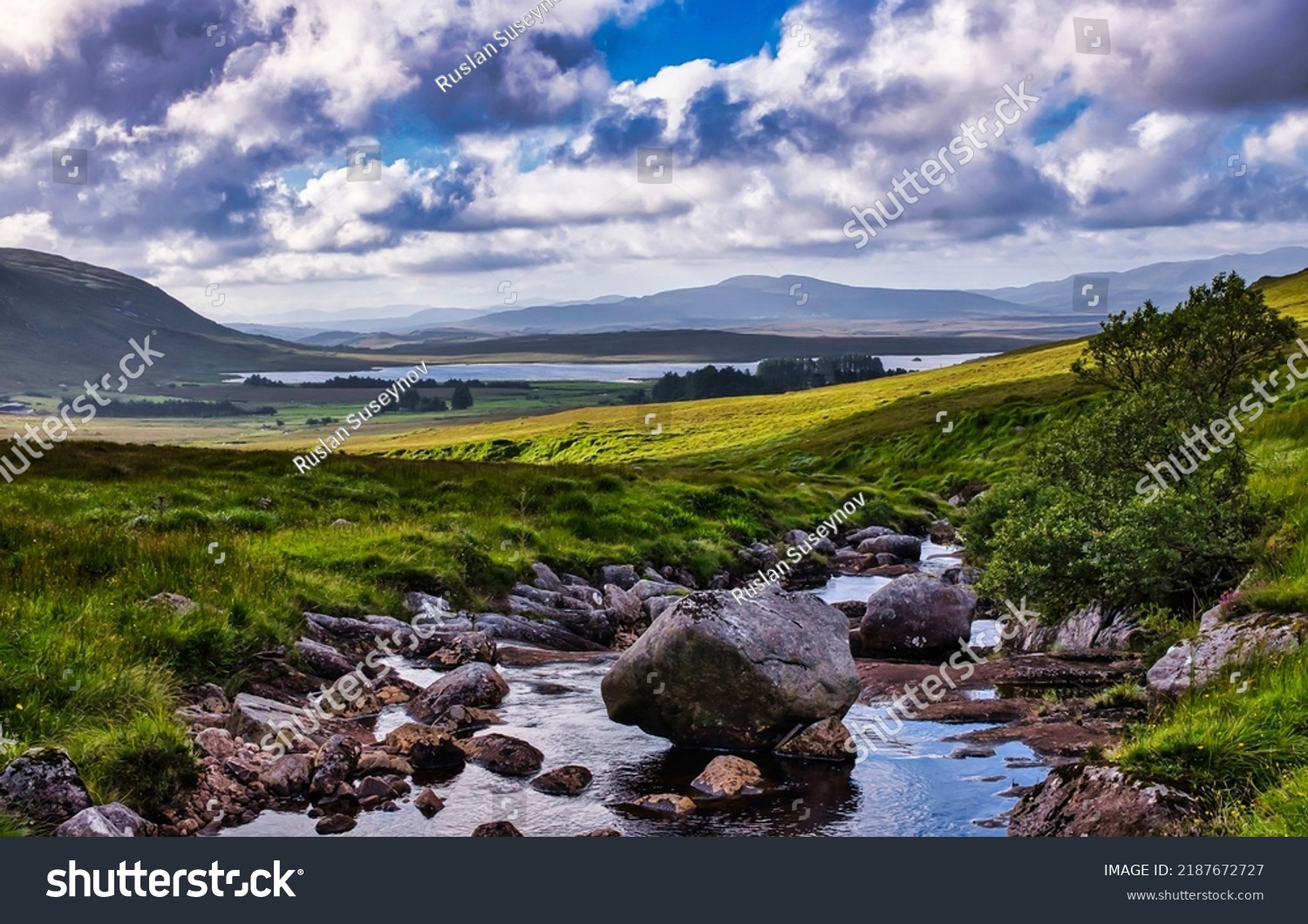 A stream in a mountain valley. River valley landscape. Beautiful river valley. Stones in water of green valley #2187672727
