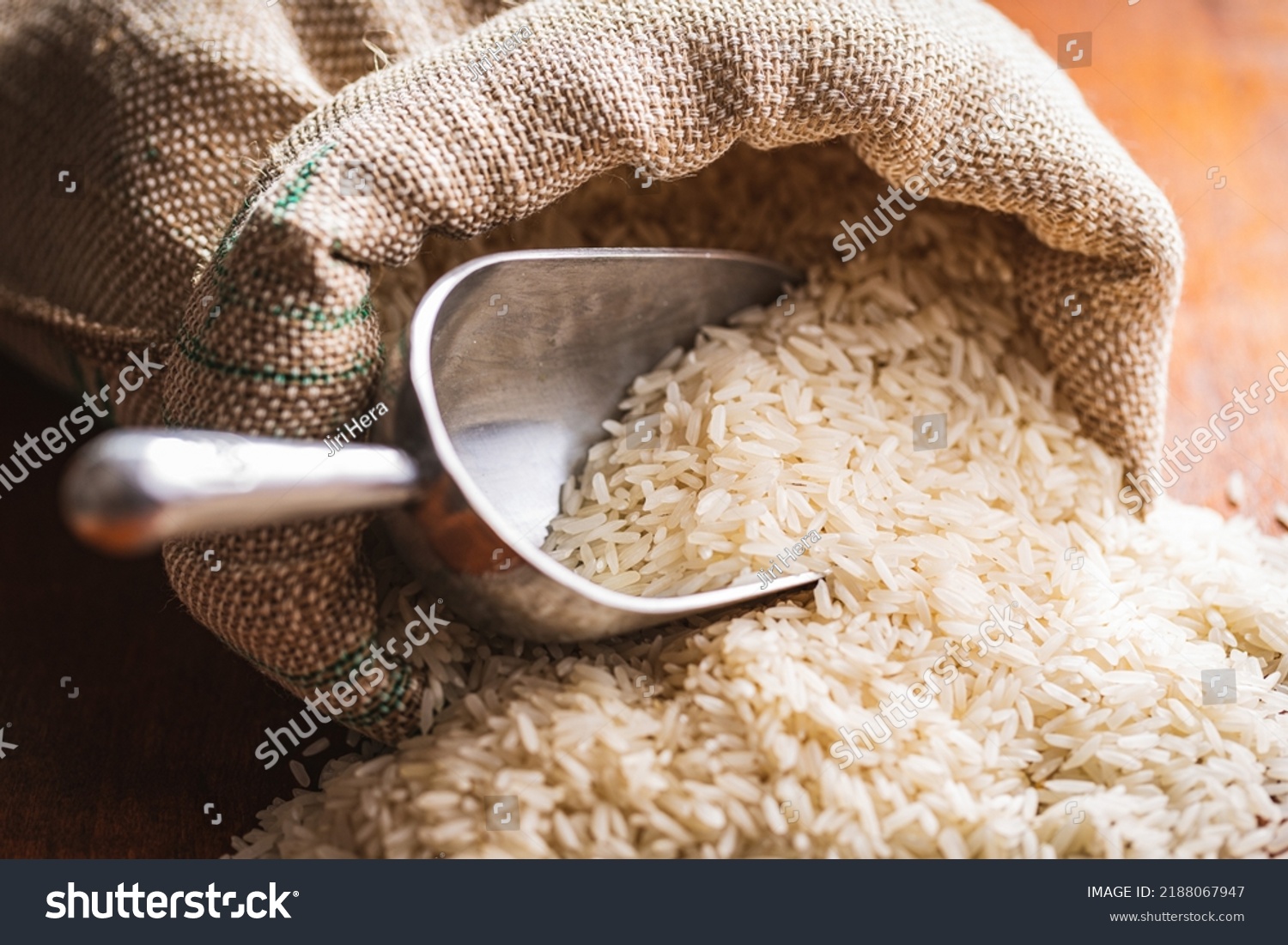 Uncooked white rice in a burlap sack on wooden table. #2188067947