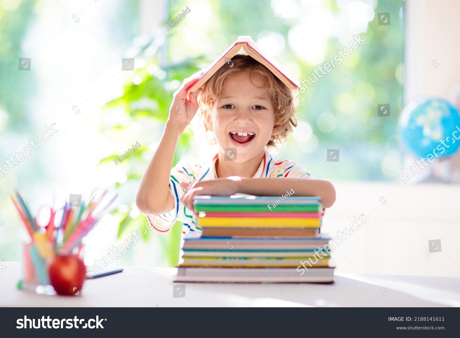 Kids go back to school. Children study and learn for preschool. Little boy of elementary class doing homework. Bedroom with desk, books and globe for young child. Kid learning to read and write. #2188141611