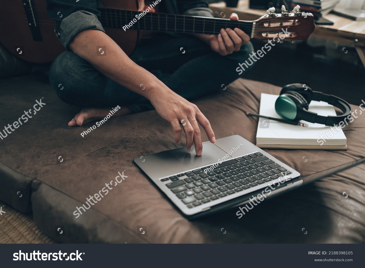 young man relax and playing guitar while sitting on sofa bed in living room at home. Music create melody song, lyrics on laptop and practice concept. #2188398105