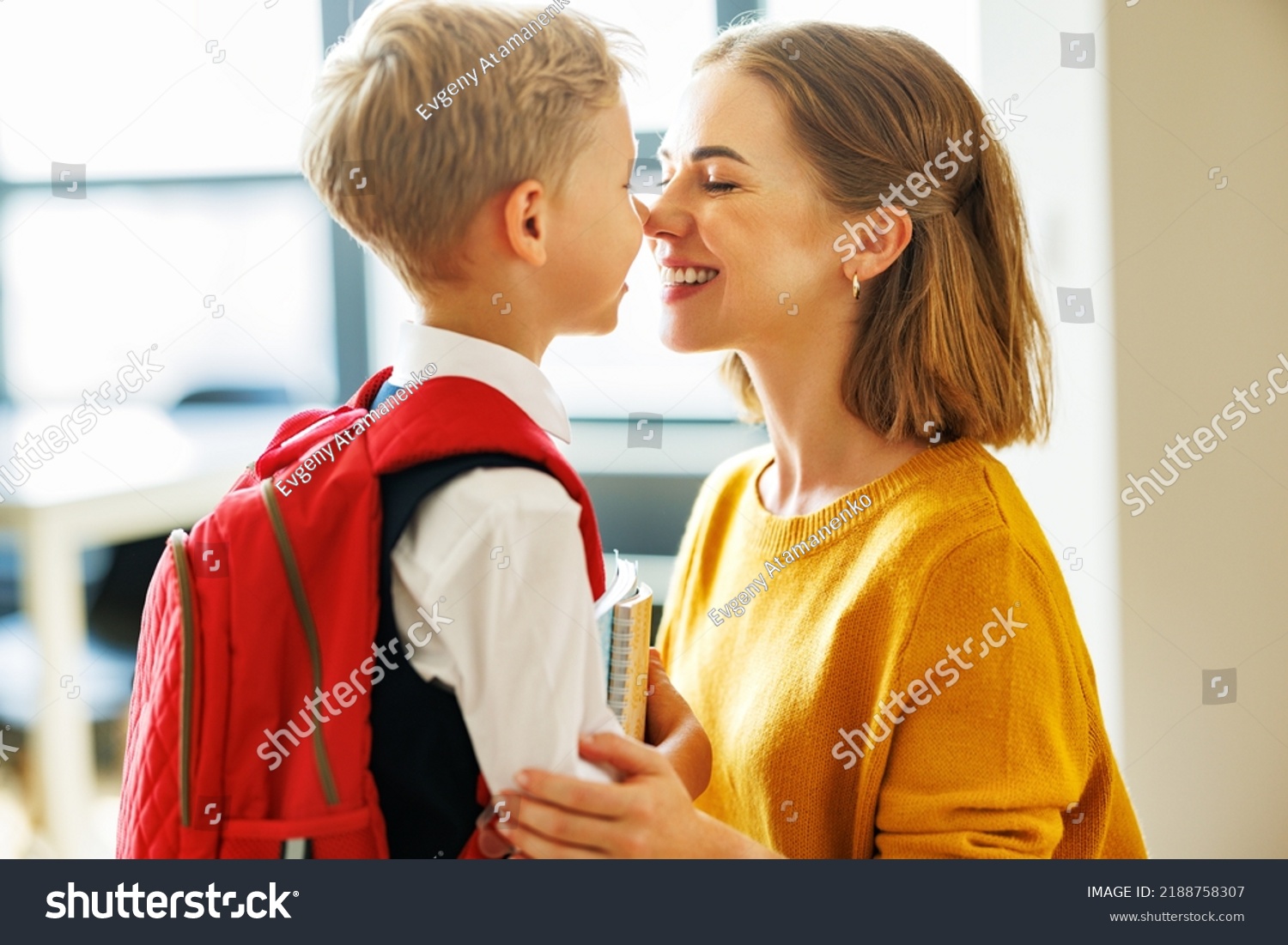 First day at school. Mother adjusts the briefcase to her happy son  during the  preparing   for school studies  at home #2188758307