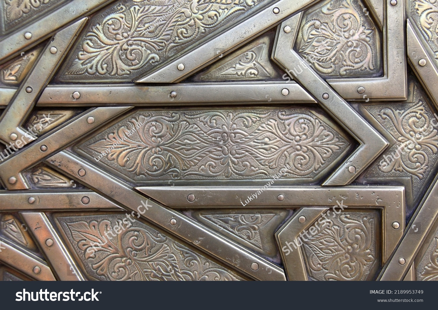 Detail of metal door with traditional islamic ornament. Copper window shutter with antique and national moroccan floral pattern. Oriental ornaments with artistic with chasing for brass #2189953749