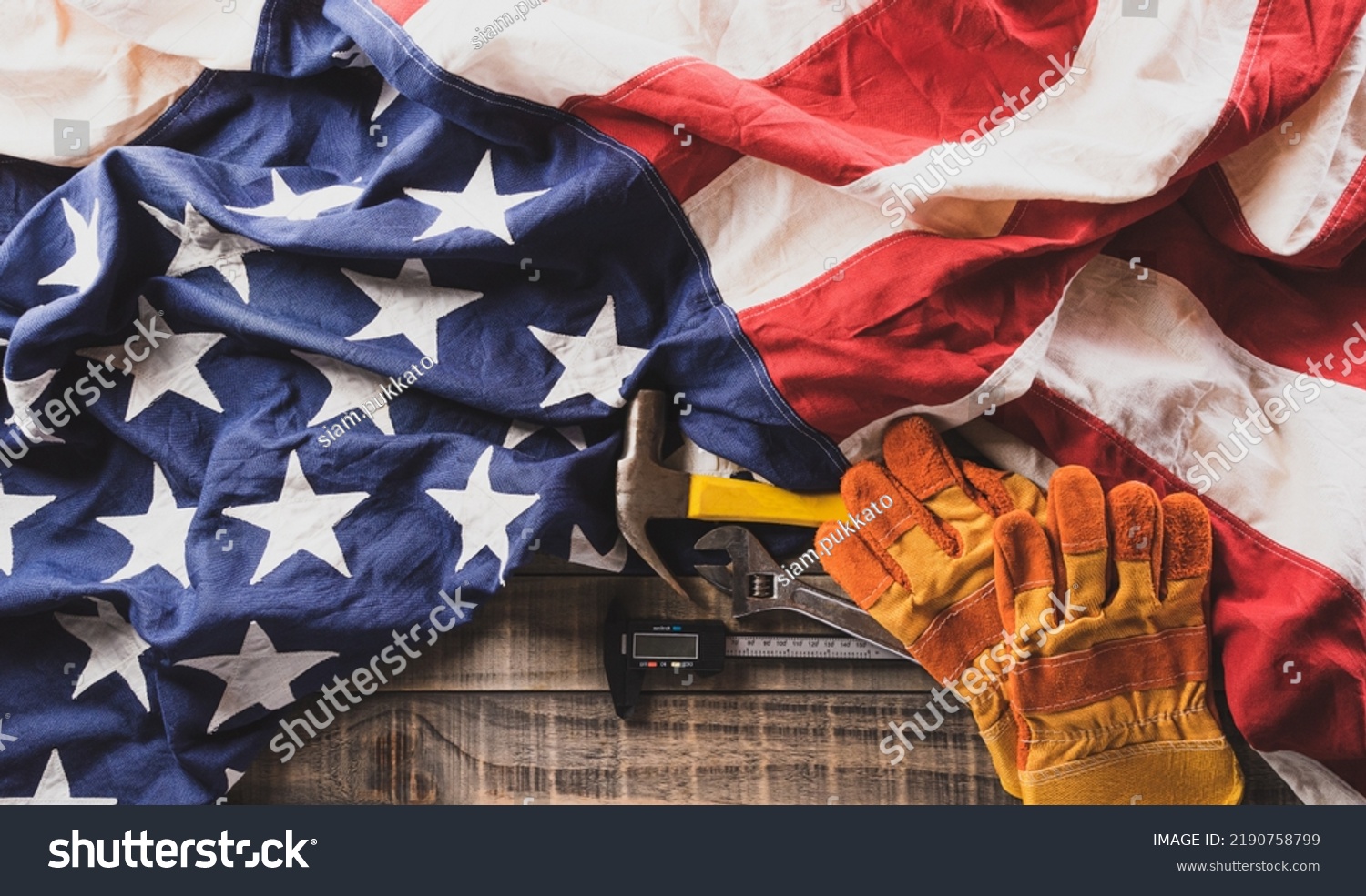 Happy Labor day concept. American flag with different construction tools on dark wooden background. #2190758799